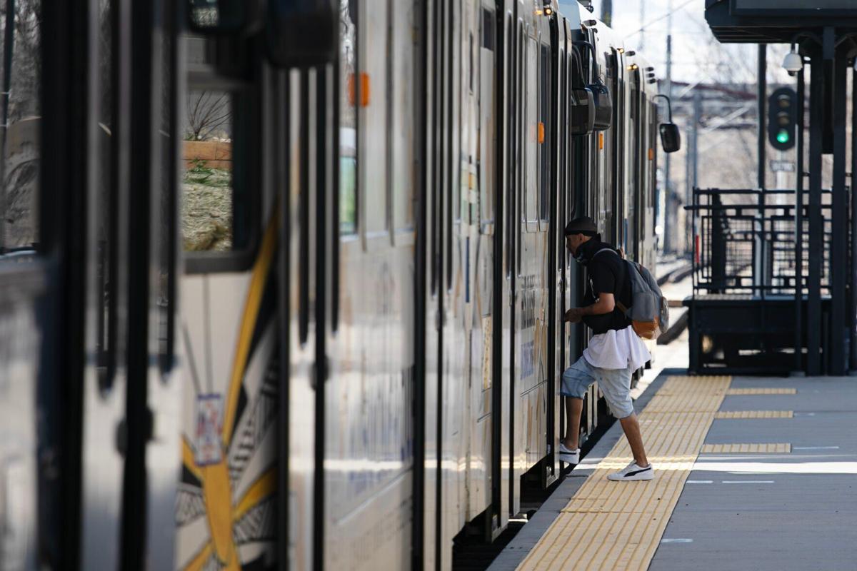 A passenger boards an RTD train at the Perry Station