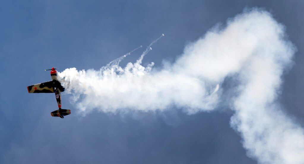 A Russian plane performs an aerobatic move in a blue sky. 