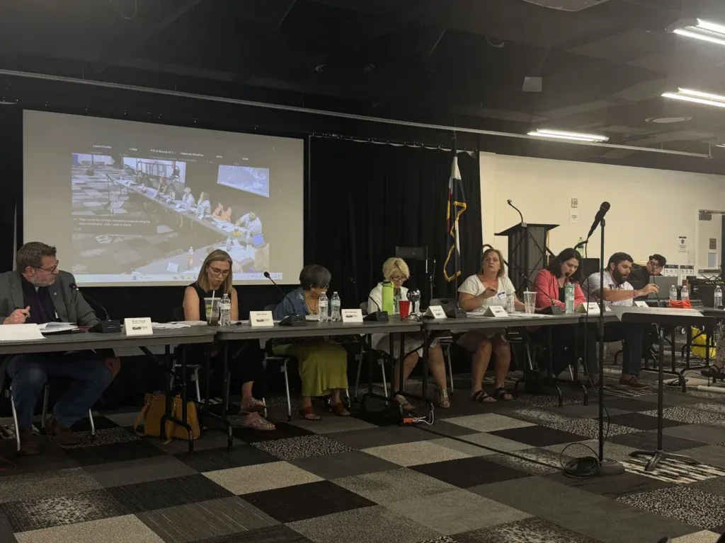 The Pikes Peak Library District Board of Directors sit behind a table during the board meeting in August 2025.