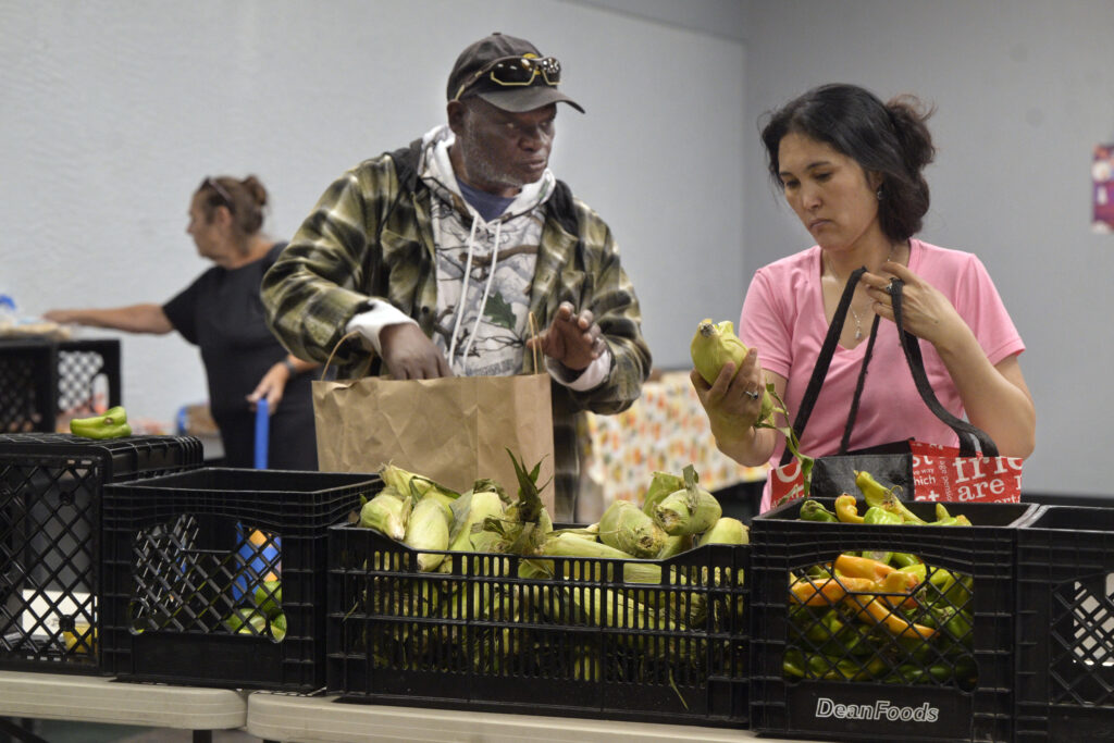 Two people in line for food distribution at Meadows Park Community Center