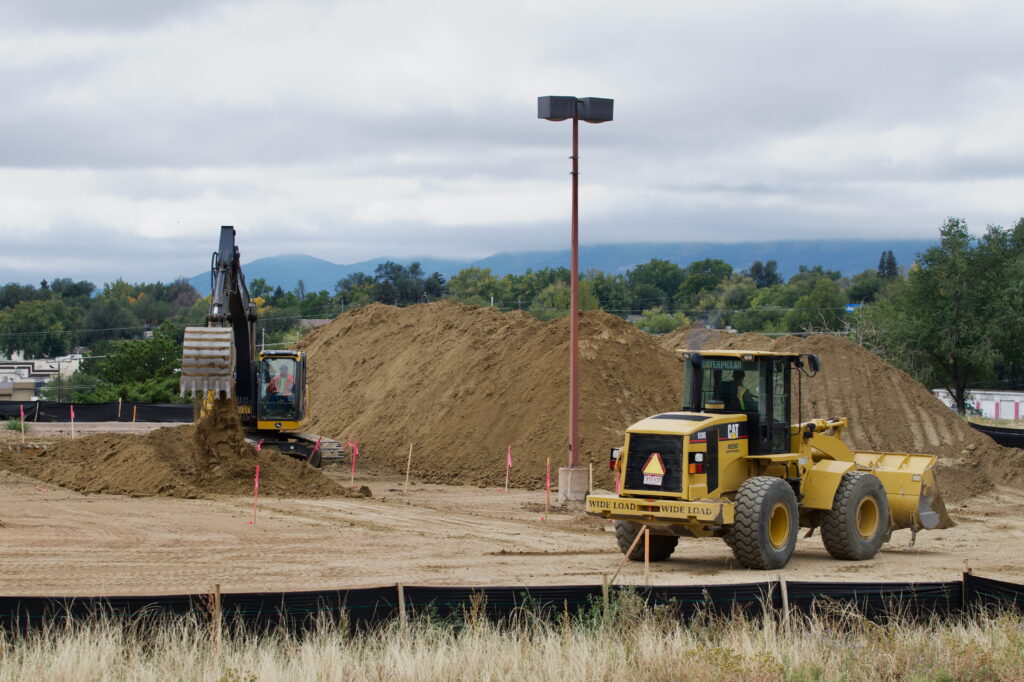 Construction vehicles move dirt as part of a new building project in Colorado Springs. The old building was a baby store and it will become a self-storage facility.
