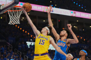 FILE - Los Angeles Lakers guard Austin Reaves (15) shoots after getting past Oklahoma City Thunder center Chet Holmgren, center, and Shai Gilgeous-Alexander, right, in the first half of Game 1 in a second-round NBA basketball playoffs series May 5, 2026 in Oklahoma City. (AP Photo/Kyle Phillips, File)